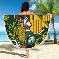 Fringed round beach blanket held overhead, green/yellow springbok graphic with “Your Text”