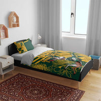 Green and yellow bedding set on bed with personalized text and bird-and-floral print, two pillows
