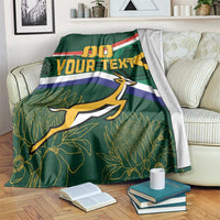 Green blanket draped on sofa, flag stripes with 00, YOUR TEXT, springbok silhouette
