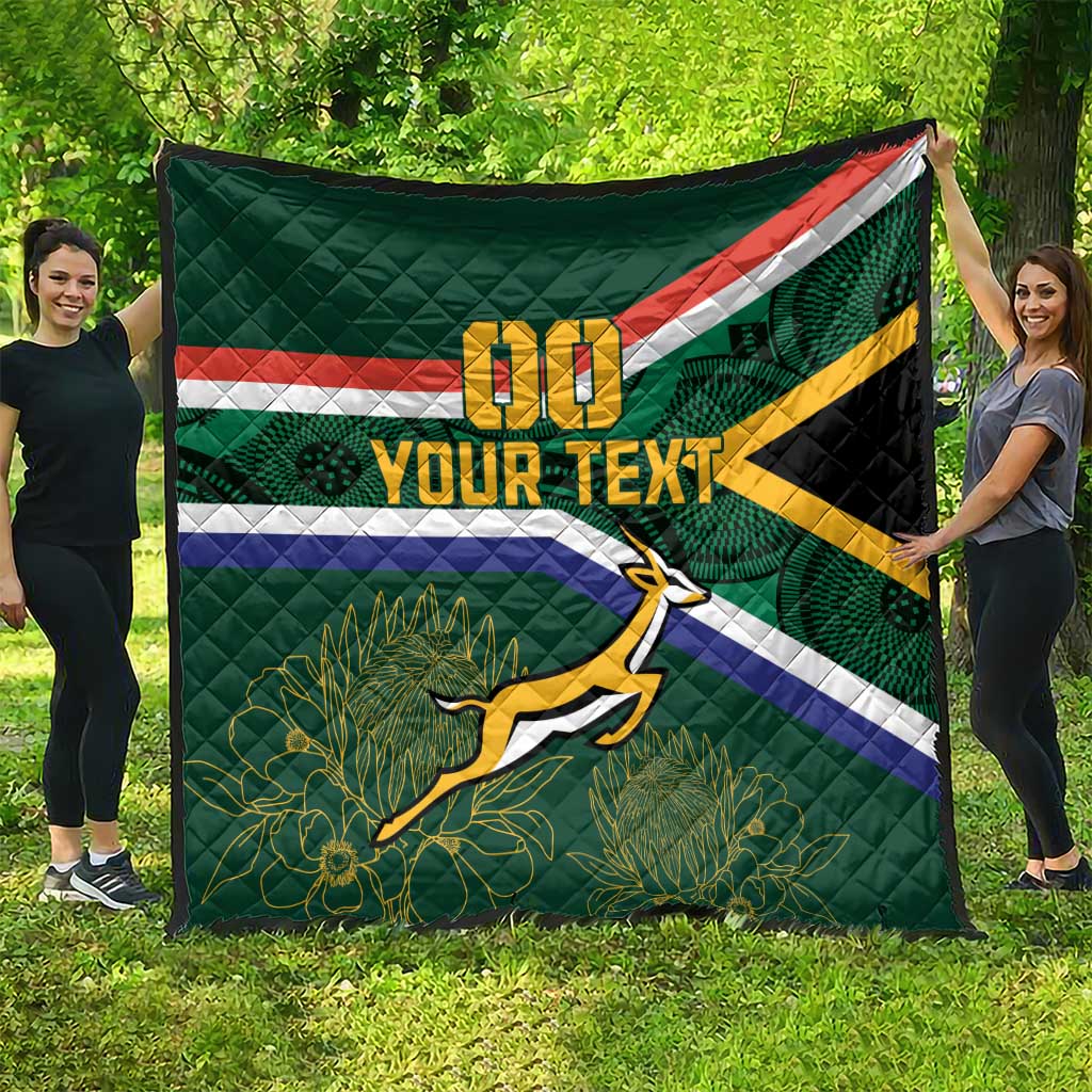 Large green quilted blanket outdoors with Springbok mascot, flag stripes, and custom text