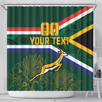 Green shower curtain with “YOUR TEXT”, springbok silhouette, floral art, and flag stripes