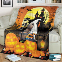 Orange Halloween blanket with haunted house scene, pumpkins, and glowing lantern graphic
