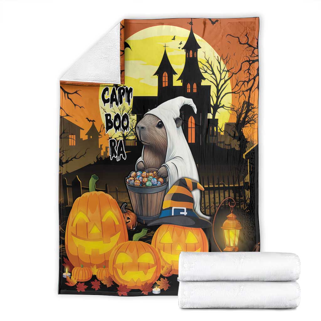 Orange Halloween blanket with haunted house illustration, pumpkins, and folded white accents