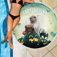 Round green Halloween beach blanket with capybara, pumpkins, and black cat silhouettes