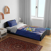 Blue bedding set with coat of arms design and kente stripe accents, paired with two blue pillows
