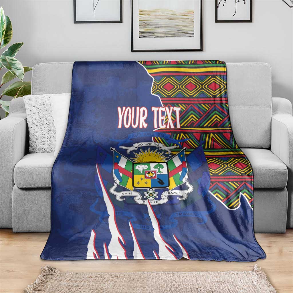 Personalized blue blanket draped over a sofa, coat of arms graphic and kente stripe top