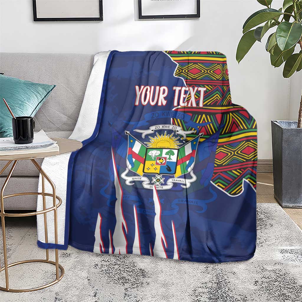 Personalized blue blanket laid over sofa seating, coat of arms design and kente border