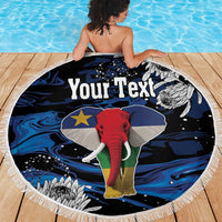 Round beach blanket with fringe, black blue elephant graphic with 'Your Text' on wooden deck
