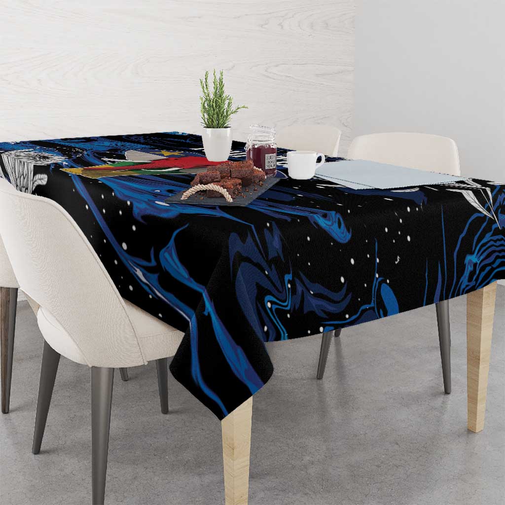 Black tablecloth with blue swirls and floral motifs draped on dining table