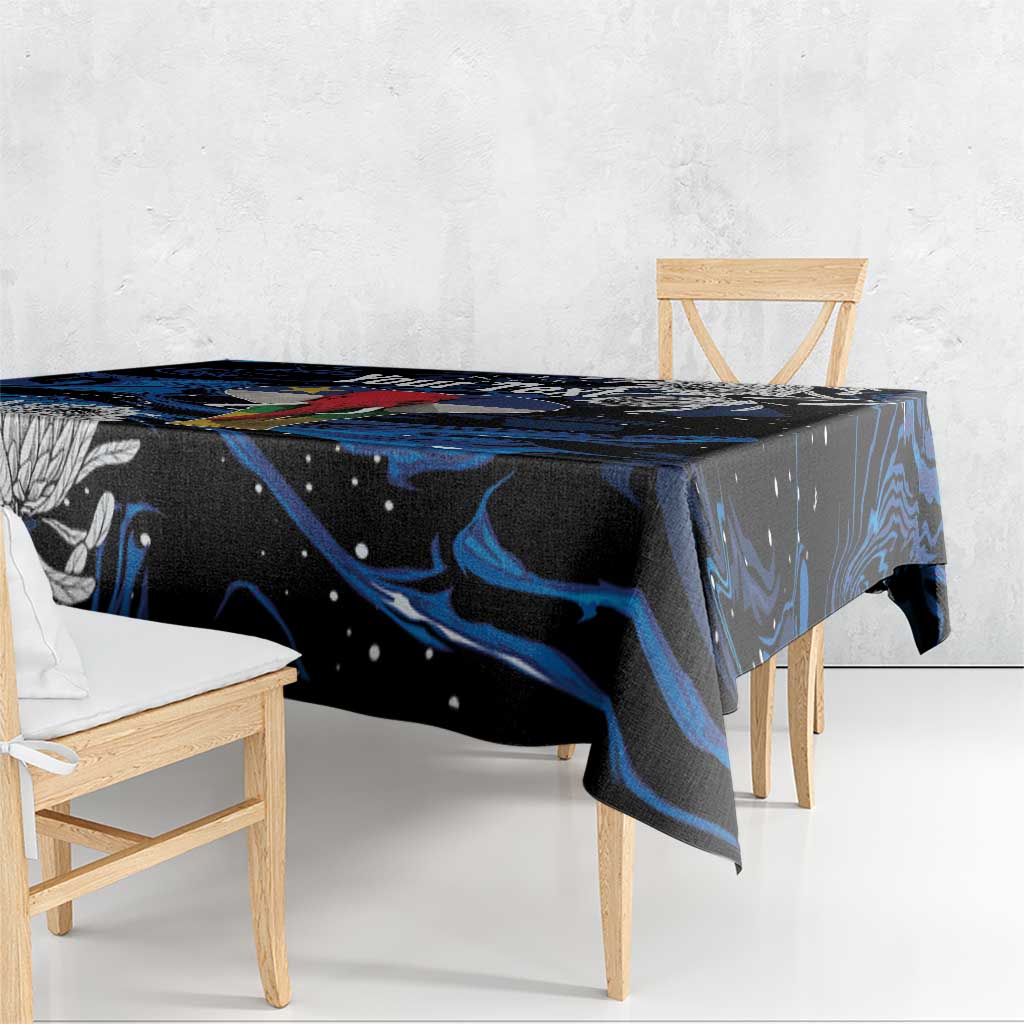 Black tablecloth with blue swirled design across tabletop edge