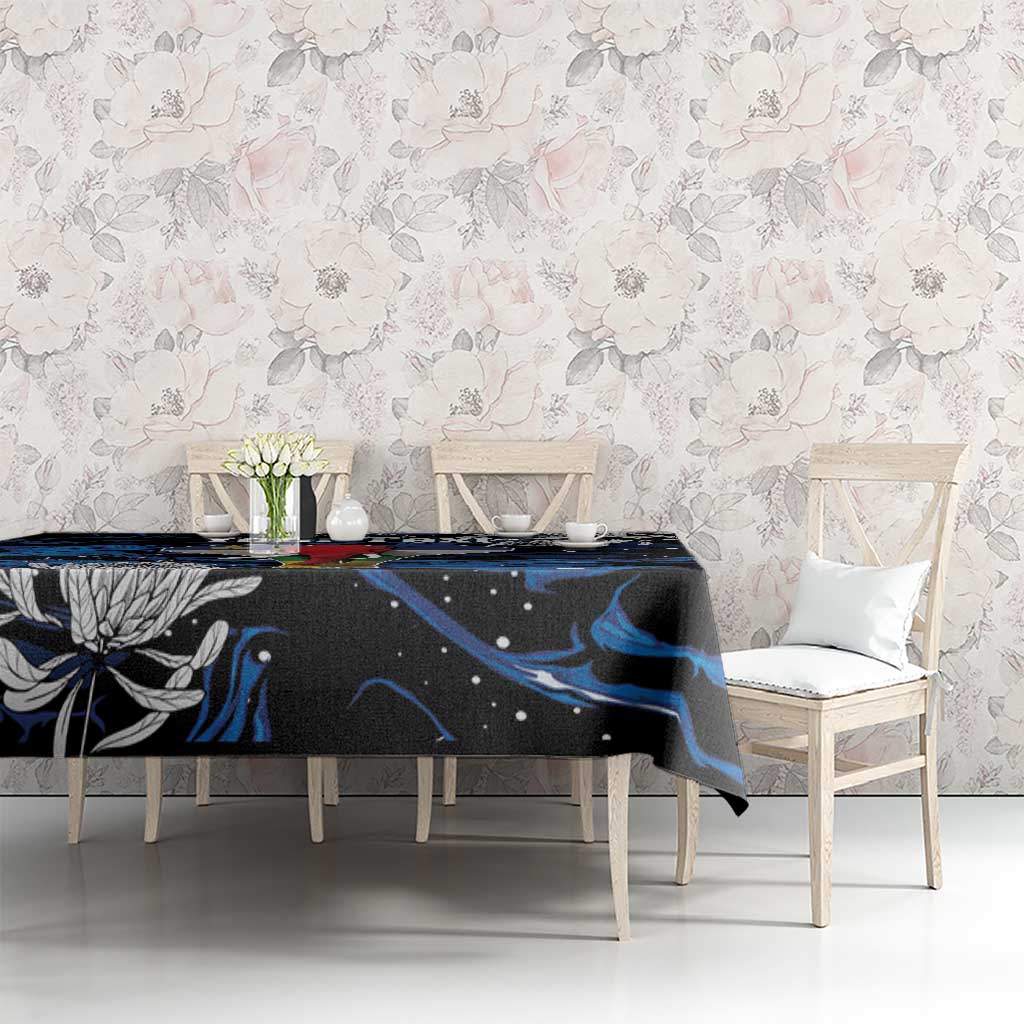 Black tablecloth with blue abstract waves over dining table with white chairs