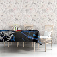 Black tablecloth with blue abstract waves over dining table with white chairs