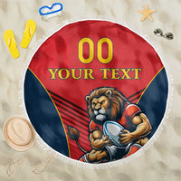 Round red beach blanket with blue border, lion mascot graphic, and white fringe edge