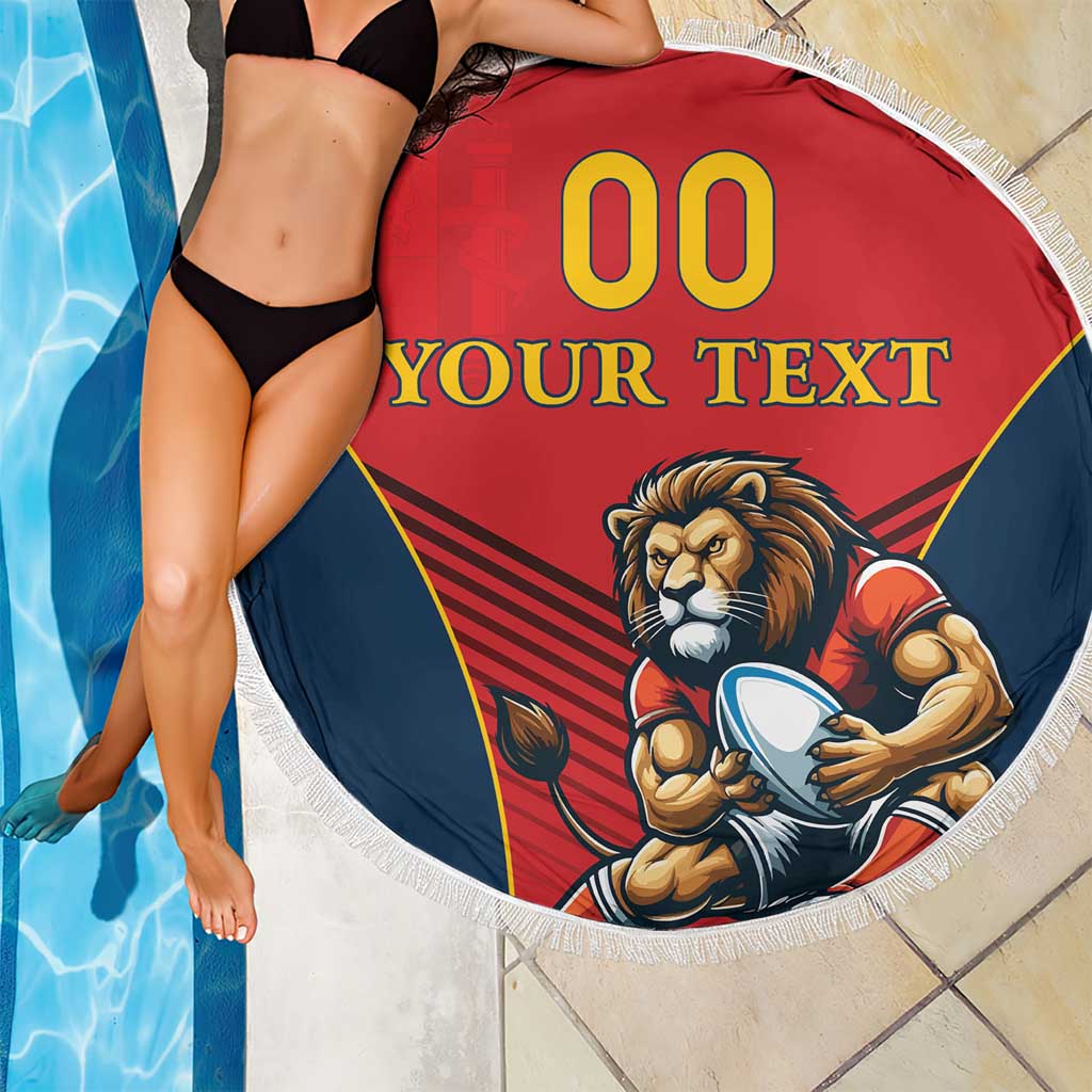 Round red beach blanket with lion mascot print, blue border, and white fringe near pool