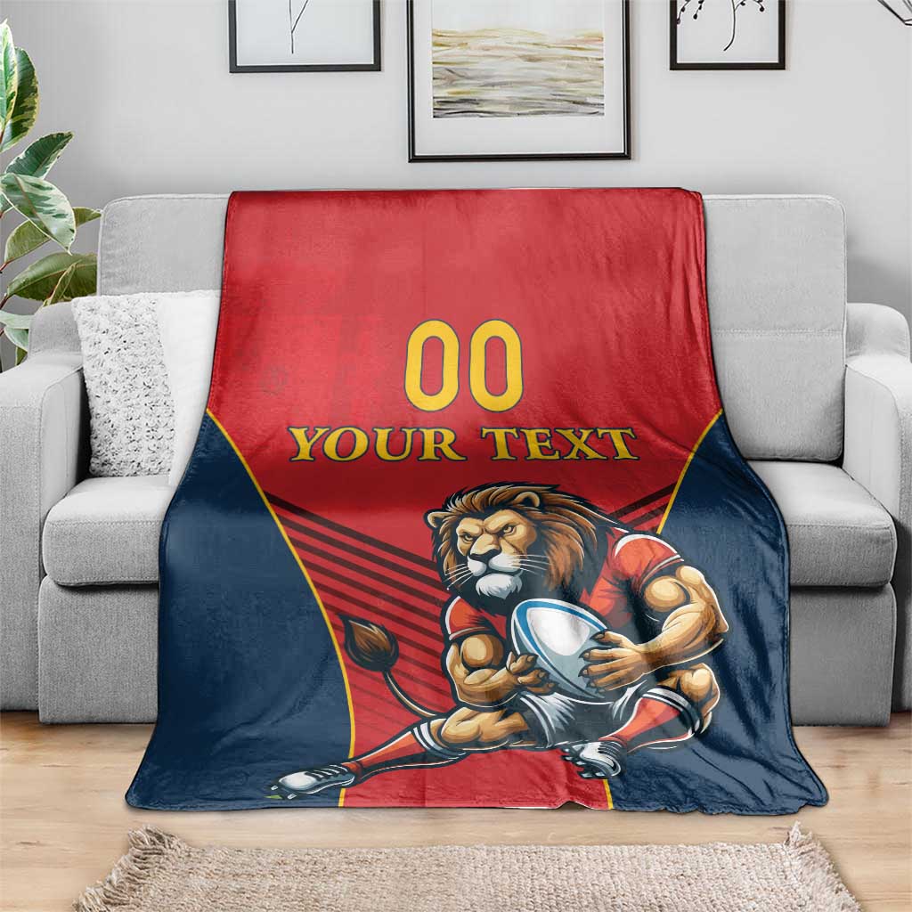 Spain rugby blanket draped on a couch, lion mascot in red and navy