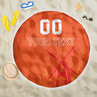 Orange round beach blanket with white fringe, custom text and windmill pattern
