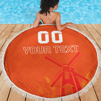Orange round beach blanket with white fringe, custom text and windmill pattern