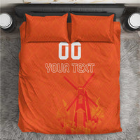 Orange duvet cover set viewed from above, two pillows, windmill graphic and “YOUR TEXT”.