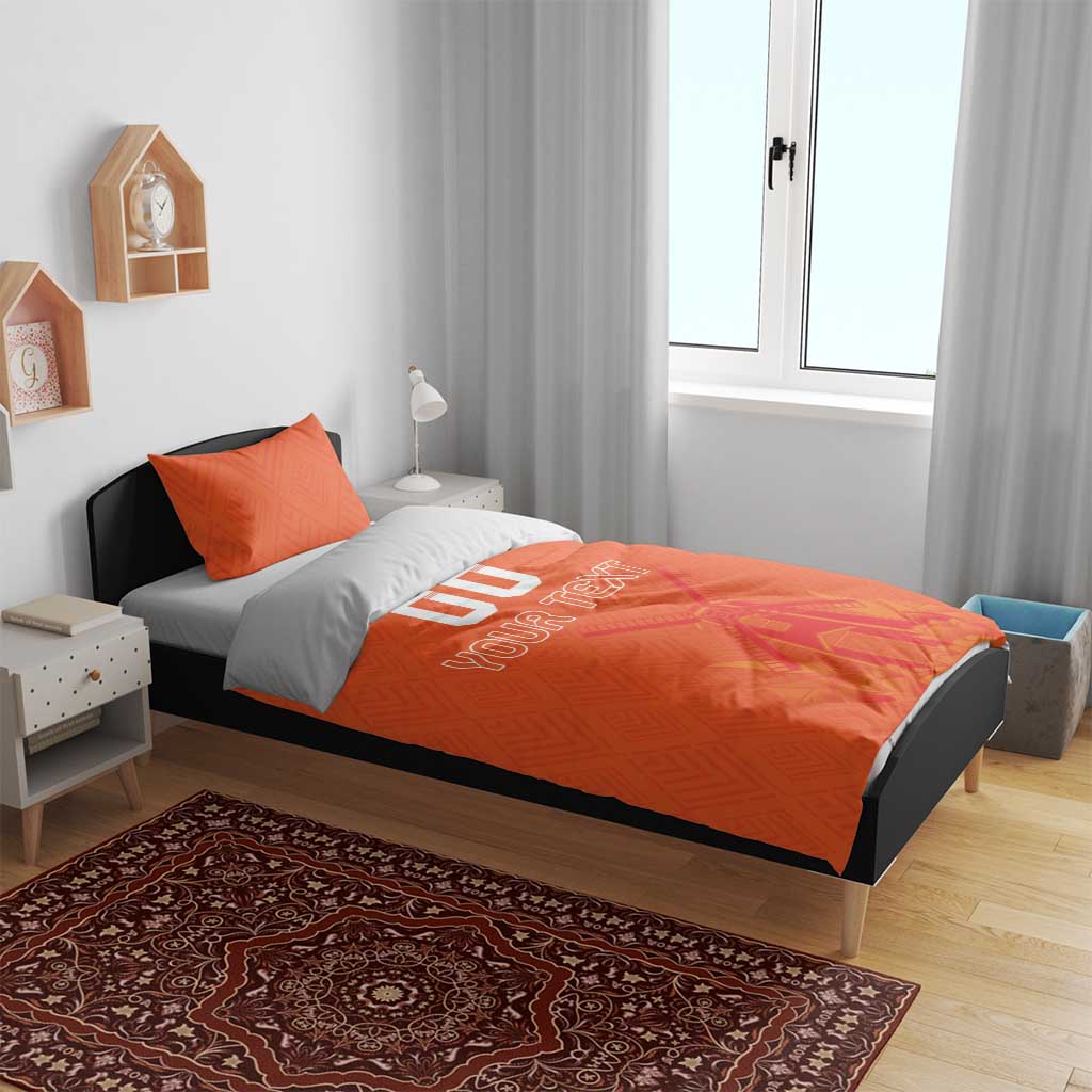 Orange duvet cover with “YOUR TEXT” and windmill artwork, plus two matching pillows.