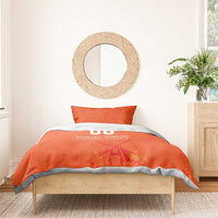 Orange bedding set on a wooden bed frame, duvet with “YOUR TEXT” and windmill design.