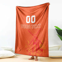 Orange rugby blanket draped open, windmill and tulip pattern with 'YOUR TEXT' and '00'