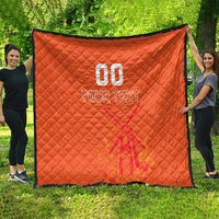 Orange quilt blanket outdoors, showing custom jersey text and number graphic with diamond quilting.