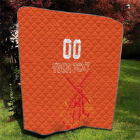 Orange quilt blanket with custom jersey-style text and number graphic, diamond stitch pattern.