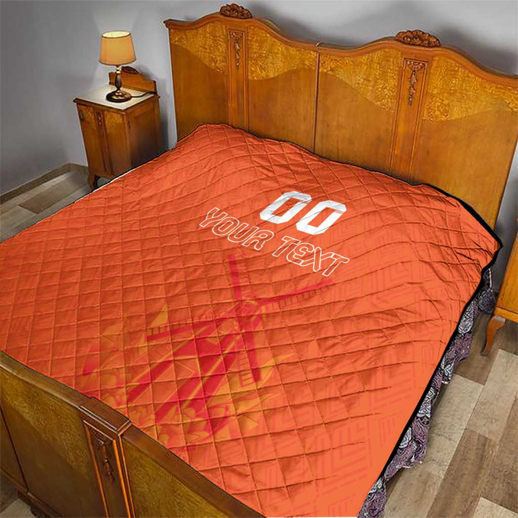 Orange quilt blanket on a bed, featuring custom jersey text and number graphic in center.