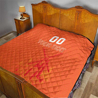 Orange quilt blanket on a bed, featuring custom jersey text and number graphic in center.