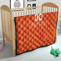 Orange quilt blanket across a small bed/crib, with custom jersey text and number graphic.