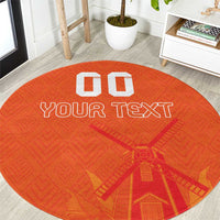 Orange round rug with “YOUR TEXT” and windmill-style graphic, custom blocks