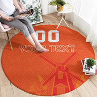 Orange round rug showing “YOUR TEXT” and windmill-style design with custom blocks