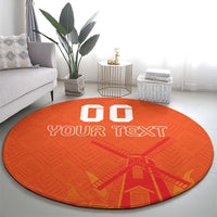 Orange round rug with “GO” and “YOUR TEXT” plus windmill-style graphic