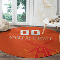 Orange round rug with “YOUR TEXT” and windmill-style graphic, white block accents