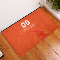 Orange rubber doormat by doorway with custom text, windmill-tulip jersey pattern