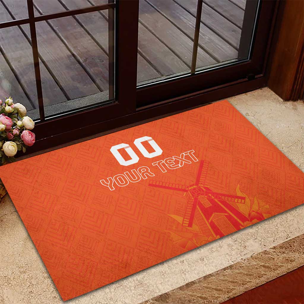 Orange rubber doormat on patio floor with custom text and windmill-tulip design