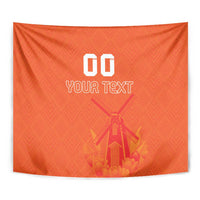 Orange tapestry wall hanging close-up: "00 YOUR TEXT" over windmill/tulip motif.