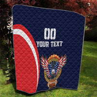 Blue quilt with red-and-white arc stripe and eagle wings holding a football emblem.