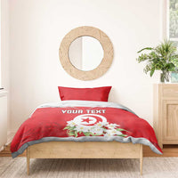 Red duvet cover with “YOUR TEXT” and Tunisian emblem, shown on a bed with pillow