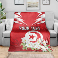 Red Tunisia blanket on sofa with white emblem, jasmine flowers, and custom text