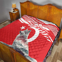 Red and white personalized quilt with gray wolf graphic on a bed, quilted fabric