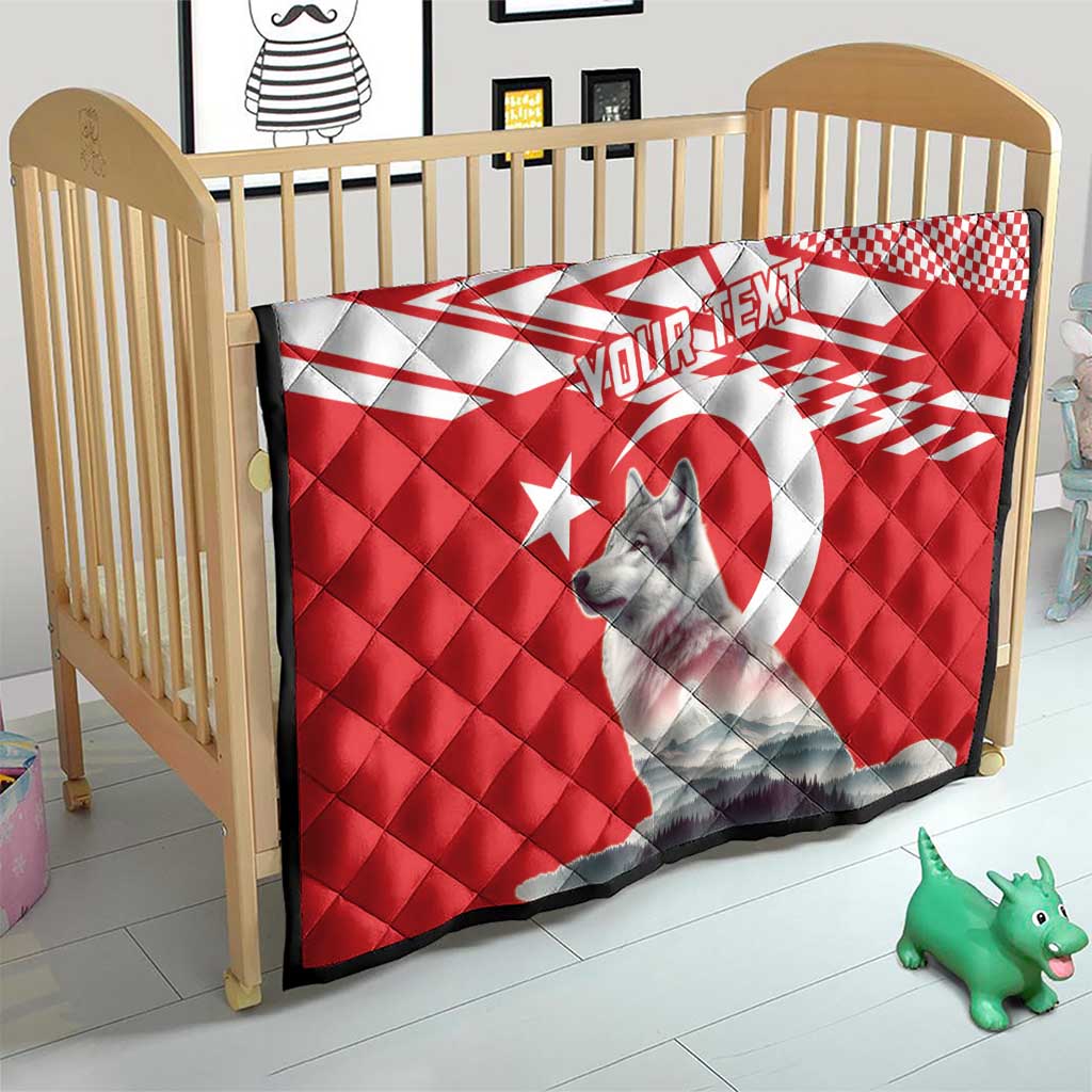 Red and white quilt with gray wolf graphic and star design on a crib