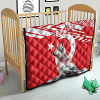 Red and white quilt with gray wolf graphic and star design on a crib