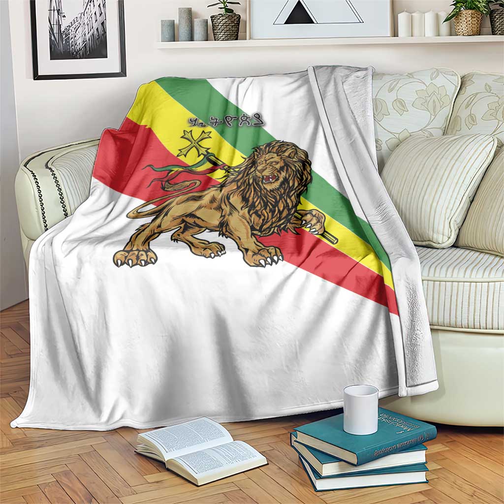 White blanket with Ethiopia flag stripes, lion and cross emblem, draped on a sofa