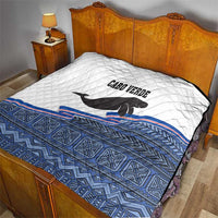 Cape Verde manatee quilt on bed, white quilted top with blue geometric base