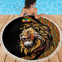 Round black beach blanket with lion head print and colorful patterned side, white fringe