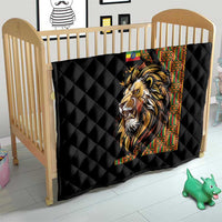 Black quilt with diamond quilting and lion graphic over light wood baby bed