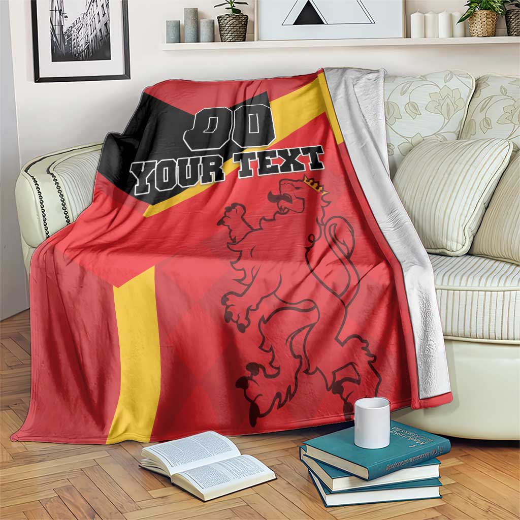 Spain football blanket draped over a couch, showing lion crest and “YOUR TEXT” lettering.