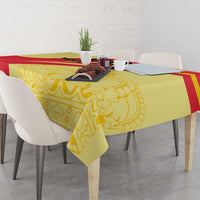 Yellow and red Spain-style tablecloth draped over dining table with chairs