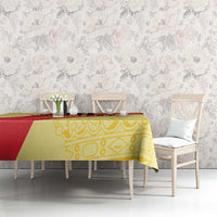 Yellow and red Spain-style tablecloth on long table with floral chairs